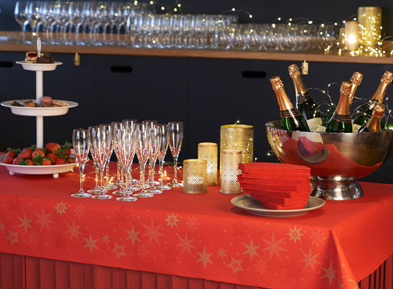 Festive drinks table with red patterned table cover and table skirt